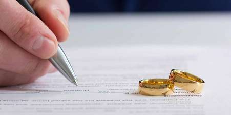 A pair of rings placed upon divorce papers, solicitors for marriage, getting married abroad legal requirements, wedding insurance