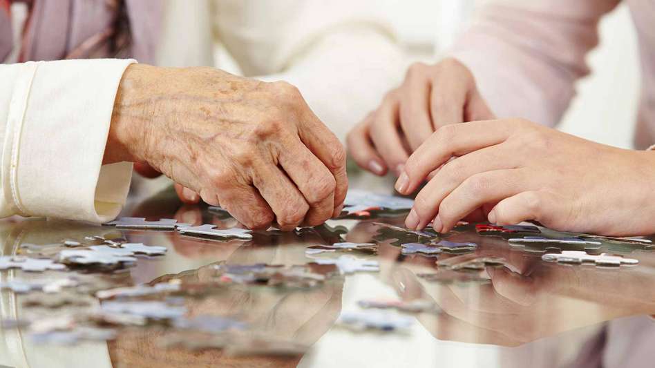 An elderly and young woman playing with a jigsaw