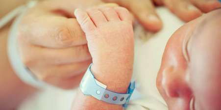 Baby holding hands with their father -placental abruption symptoms, placental abruption causes article