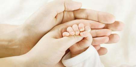 New born baby holding hands with their parents