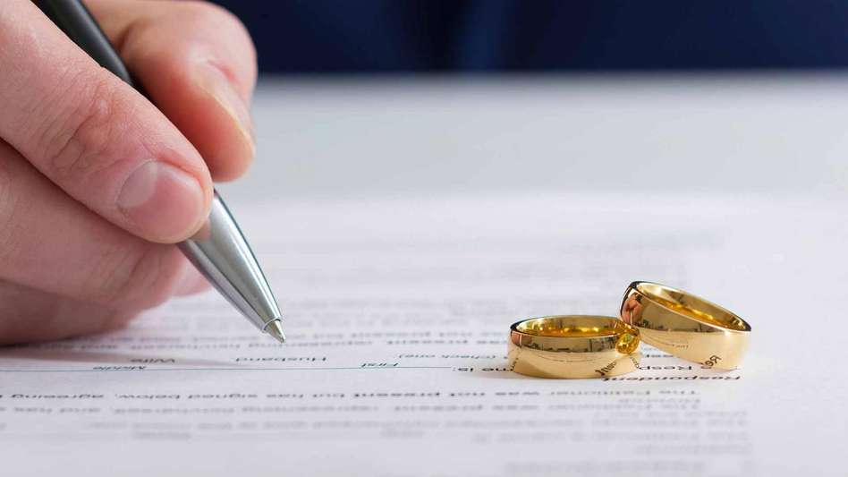 A pair of rings placed upon divorce papers, solicitors for marriage, getting married abroad legal requirements, wedding insurance