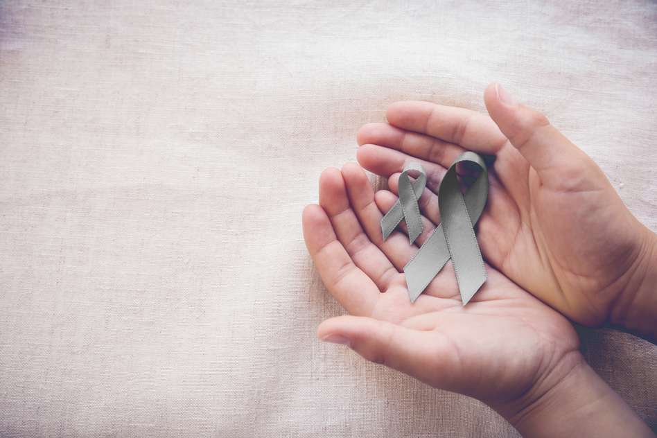 Two hands holding a cancer logo