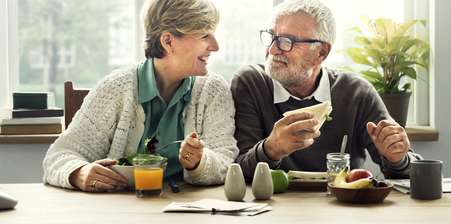 an older couple enjoying sandwiches together | independent financial advice pensions