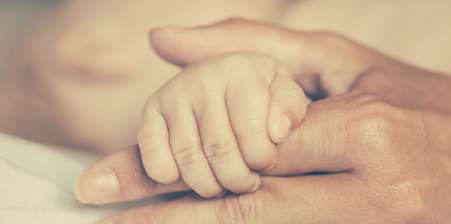 Mother holding baby hand