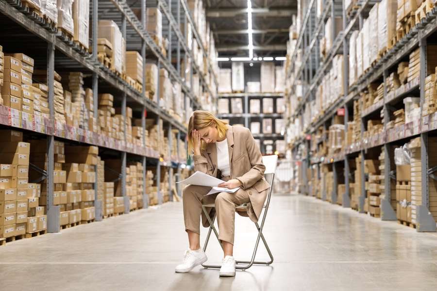 How to protect your assets before marriage UK and protecting assets after marriage UK, a worried woman business owner sitting in a warehouse , looking down at papers in her hands