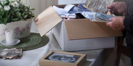 Someone packing a loved one's pictures and valuables after their death