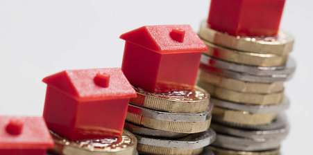 pound coins and toy houses illustrating inheritance tax