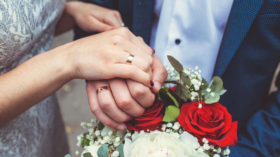 Newly married couple holding flowers