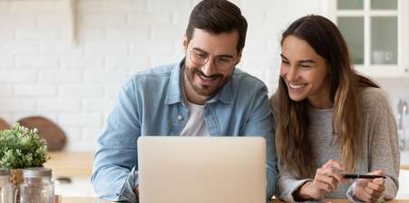 Couple sitting at a computer with a smile