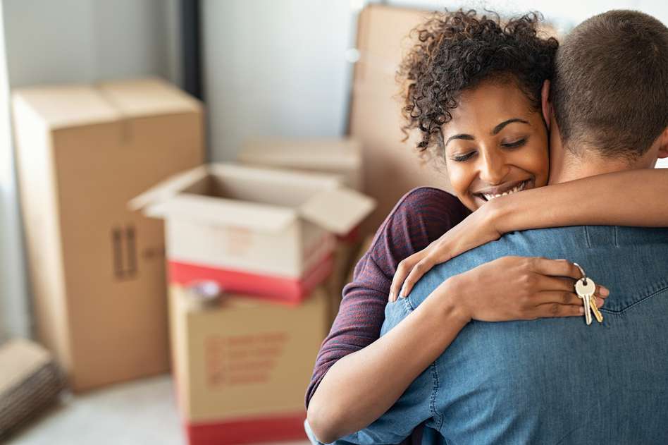 Couple hugging in front of boxes