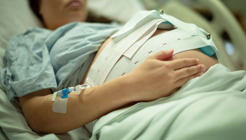 Pregnant Woman laying on a hospital bed