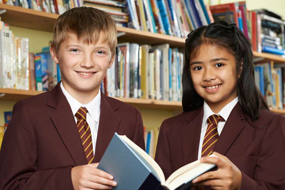 Two students holding a schoolbook