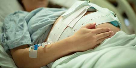 Pregnant Woman laying on a hospital bed